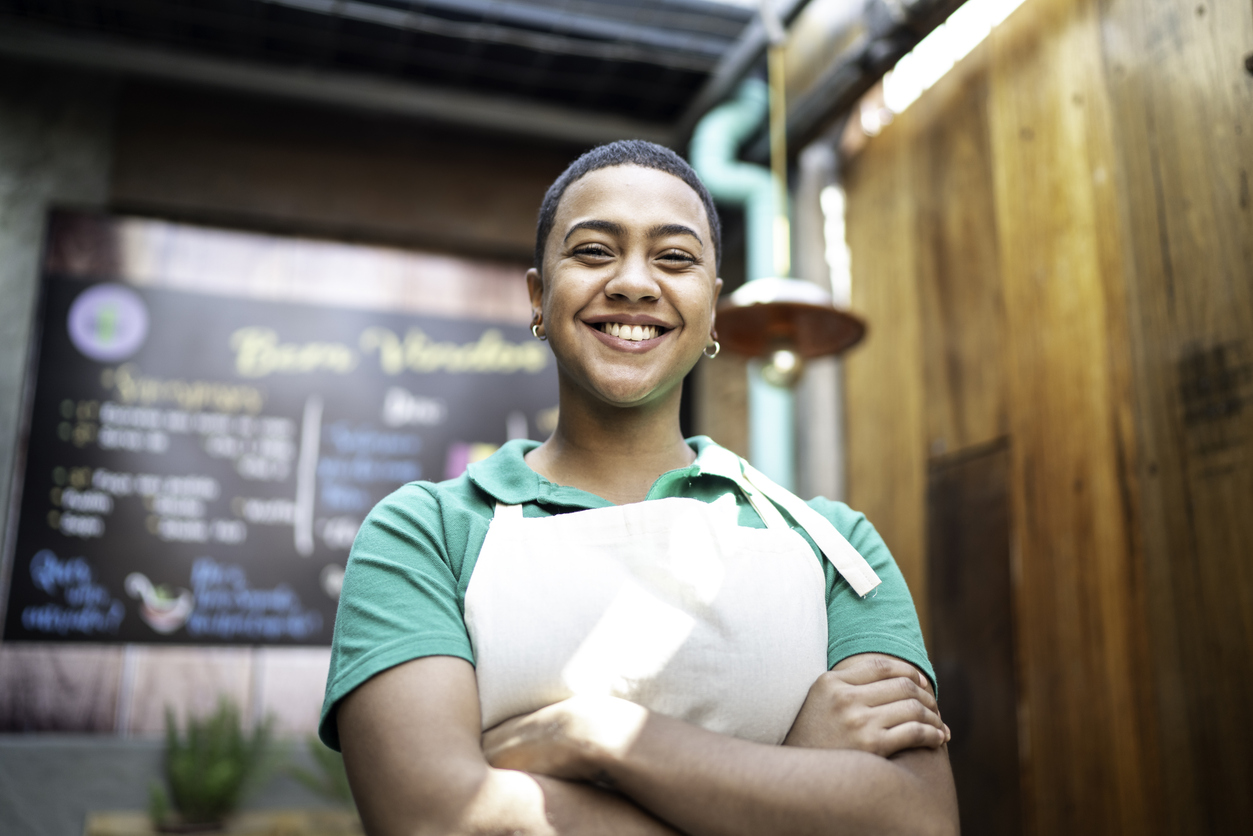 Portrait of a young business owner standing in front of restaurant with arms crossed