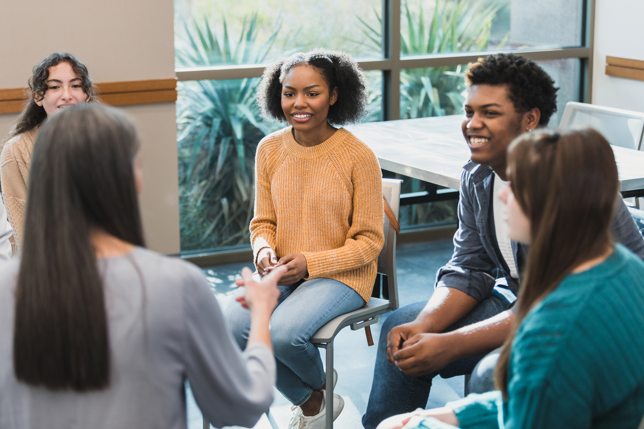 Unrecognizable female therapist leads teen therapy group